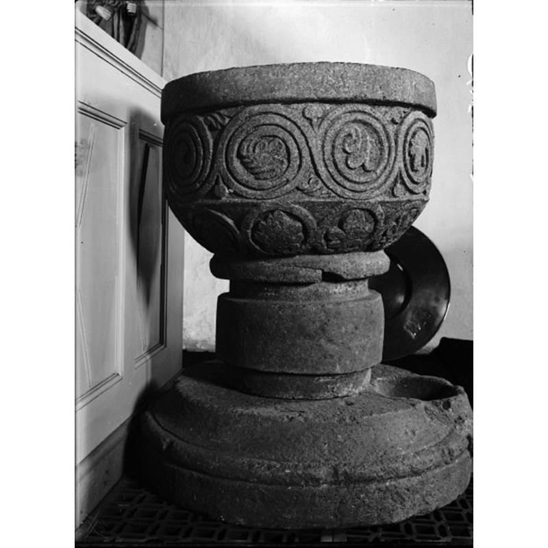 the round baptismal dish stands behind the font
