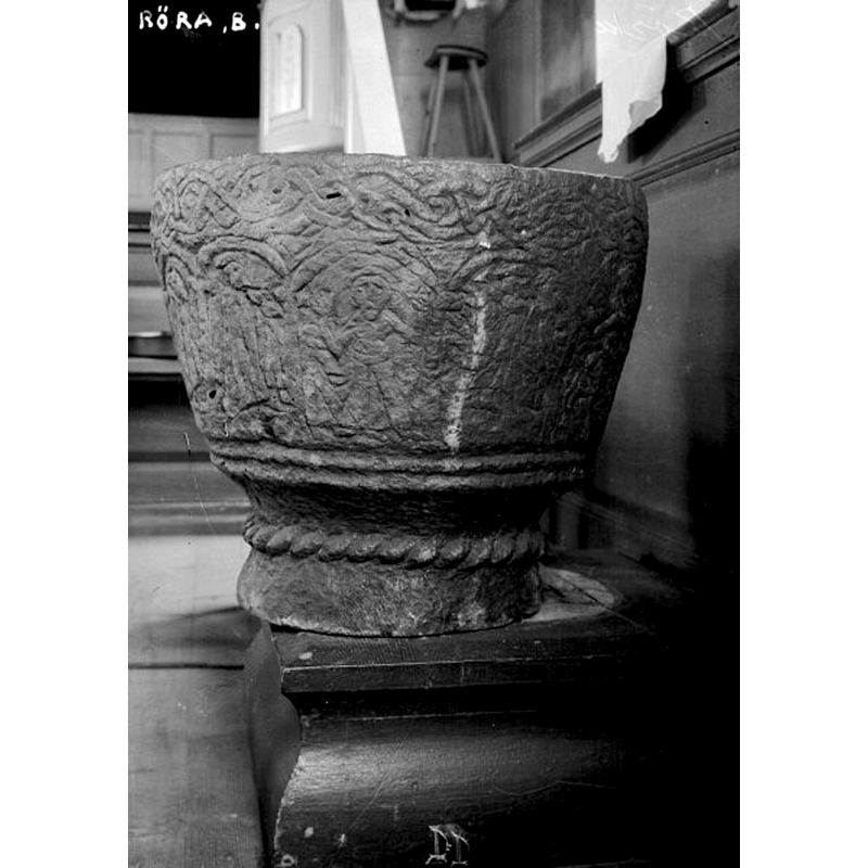 standing precariously on an old wooden base; to judge by the mark left on the wooden base, the font was probably moved off its centered position in 1918, during the inventory