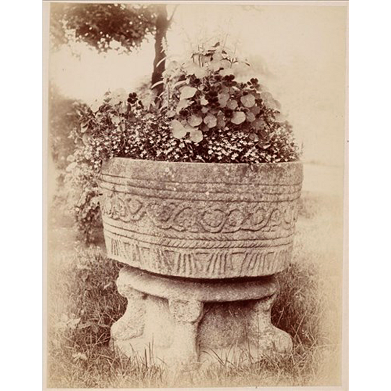the font at the time it served as a garden ornament in a public park [NB: it was returned to the church in 1891]