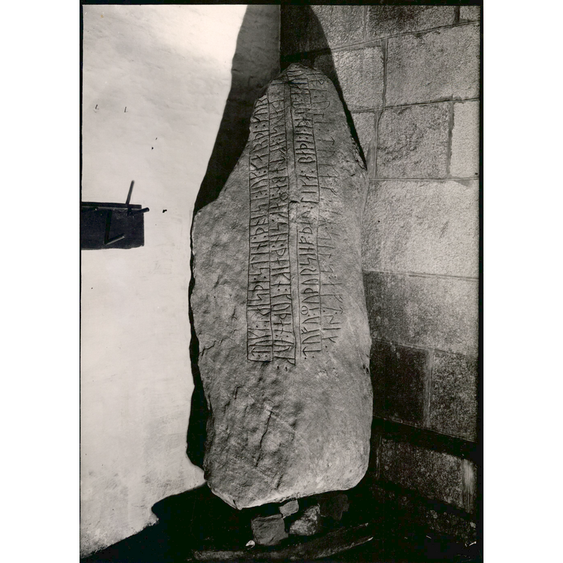 one of the two stones in the 'våbenhus' -- Source caption: "Gunderup runesten 1. Beskrivelse. Runesten fra 900-tallet i Gunderup Kirkes våbenhus med indskriften 'Toke rejste disse sten og gjorde disse kumler efter sin måg (stedfader) Ebbe, en god thegn, og Tove, sin moder. De ligger begge i denne høj. Ebbe undte Toke sit gods efter sig.'" [Tove erected the stone in the memory of his stepfather Maag, a good thane, and his mother Tove]