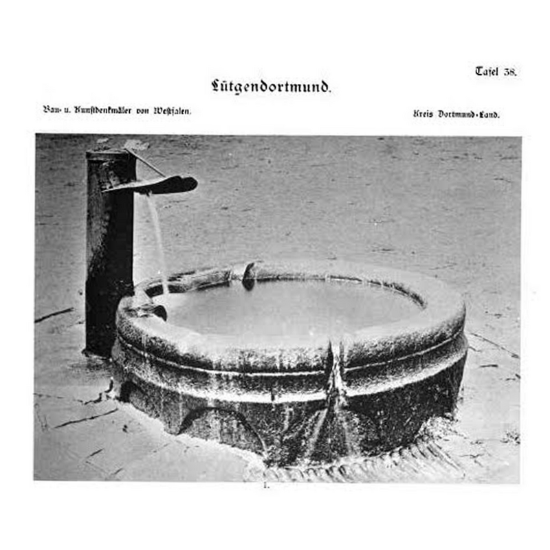 the upper area of the font shown here being used as trough of a public fountain in Lütgendortmund [the photograph is not dated but the source was published in 1895]