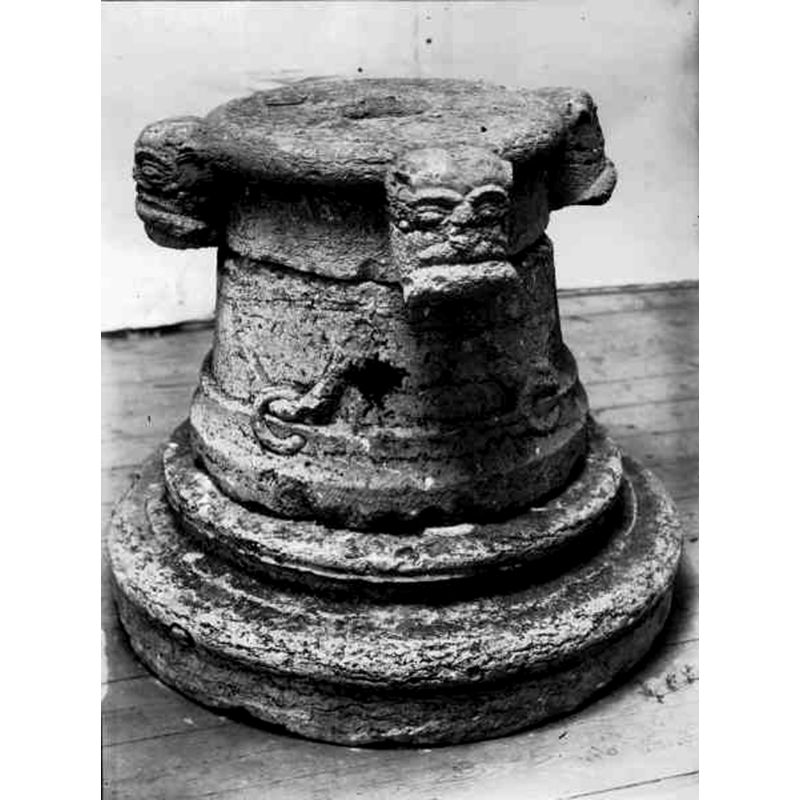Source caption: "Dopfuntfot i kalksten, sirat med mänskliga huvuden och bitande ormar. Från 1200-talets mitt." -- notice the centre drain hole at the top