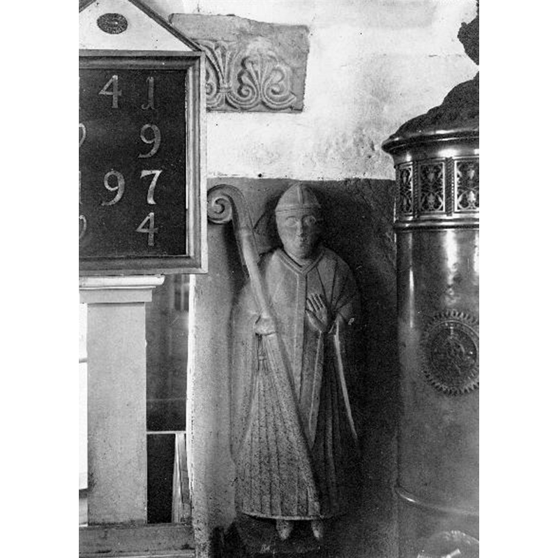 Source caption: "Stenskulptur föreställande biskop, inmurad i östra långhusväggen." -- notice also the lovely palmette frieze above; there isnother one on the north side of the chancel arch