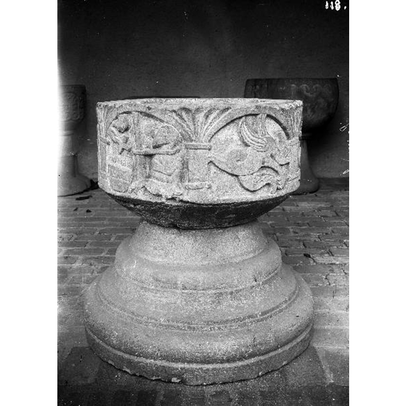 several of the fonts of churches in the area -two of which are visible here in the background- were photographed at the time with this background, obviously when the fonts had been removed from the churches [and the churches themselves were being renovated?]