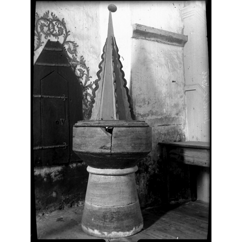 the font as shown in 1915, after its repair but before the restoration -- Source caption: "Dopfunt av kalksten. Senmedeltida. Locket från 1600-talet, "torn" på medeltida lockbotten."