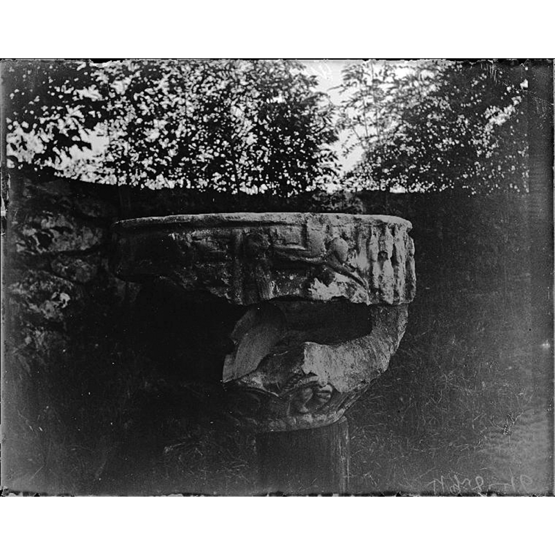 as it was in 1904, the basin raised on a wooden post-- it appears to have been located in the churchyard or rectory garden -- on the upper part of the basin sides can be discerned [L-->R]: Dream of the Magi (heads on the right); Deposition of Christ; soldiers with Jew hats, part of the Arrest of Christ