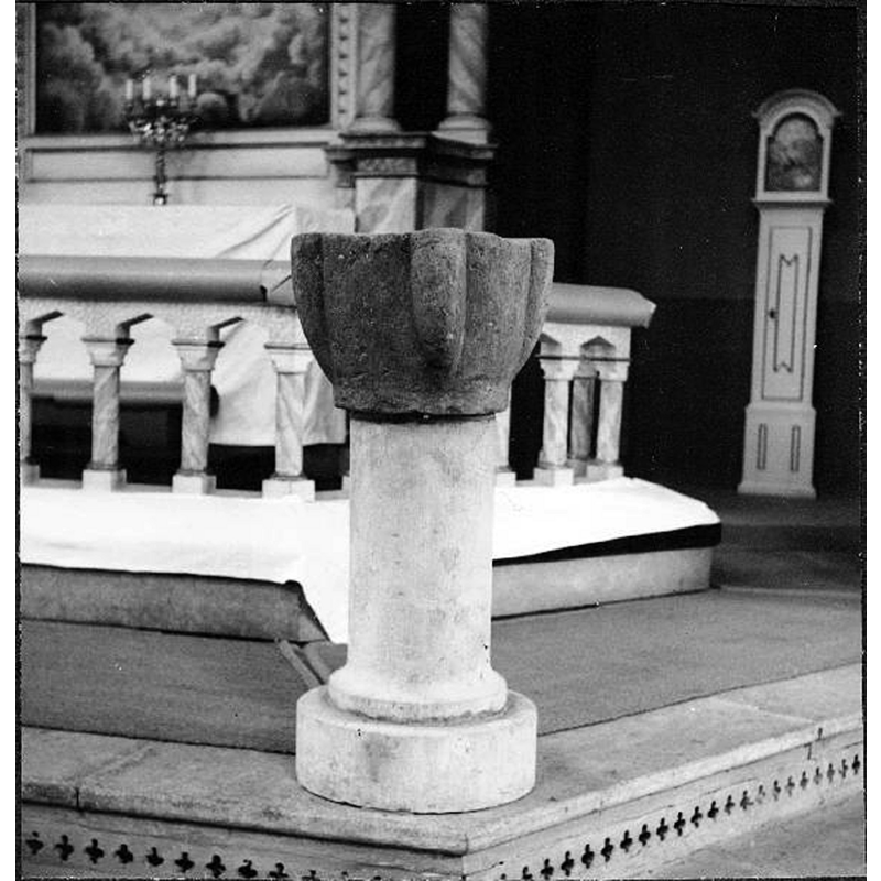 the old stoup(?) mounted on a stone cylindrical pedestal base and serving as baptismal font in 1958