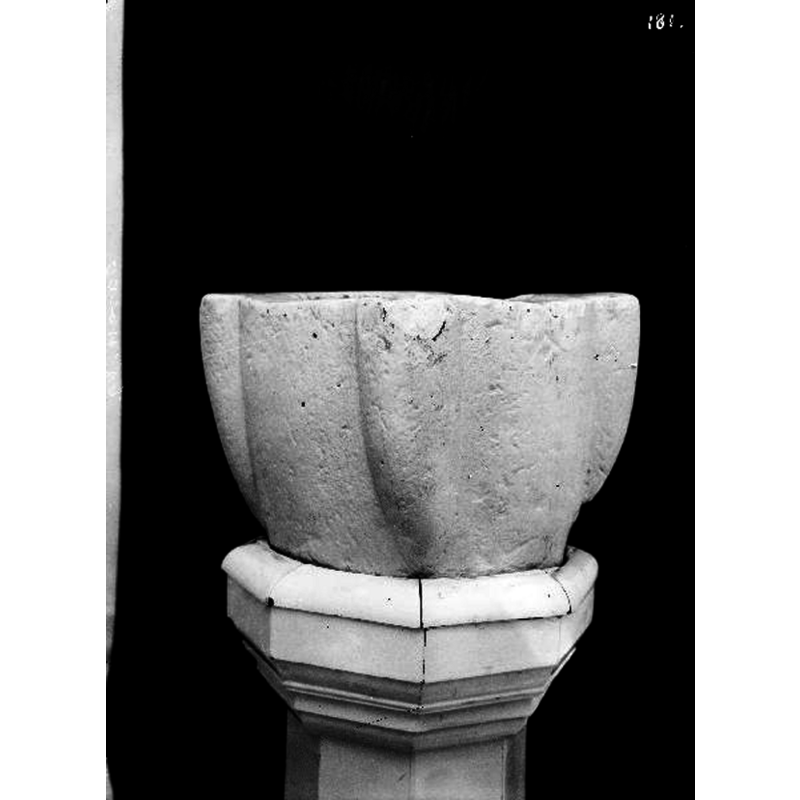 the old stoup(?) mounted on a wooden octagonal pedestal base and serving as baptismal font in this church