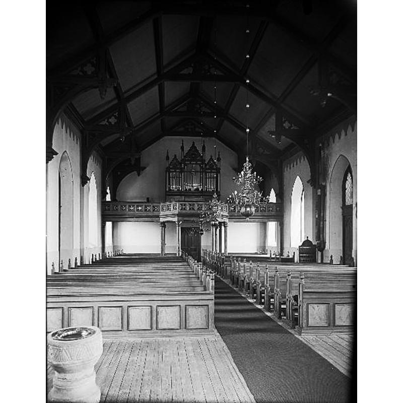 the baptismal font at the southeast end of the nave of the new church -- the photograph tates probably from the 1930s