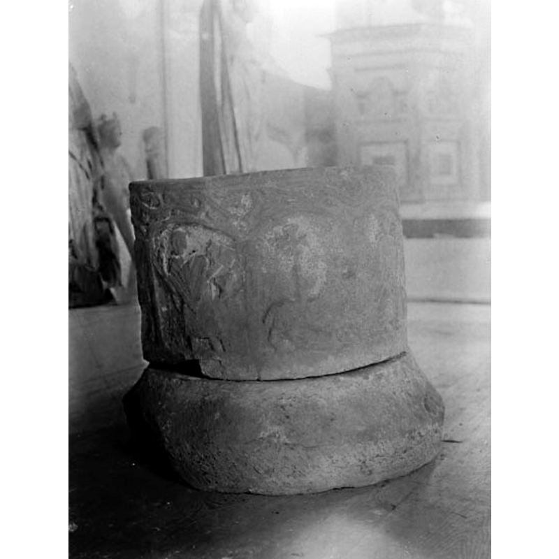 the source caption for this photograph reads: "Kestad kyrka. Funt i Fornminnesföreningens museum i Edåsa. Nu i Västergötlands museums samlingar. Återlämnad till Kestad kyrka."  It was taken by Ernst Fisher probably ca. 1910 while the Kestad font was on display in the then temporary museum of the Västergötlands fornminnesförening at the parish church of Edåsa -- that church would eventually revert to its liturgical function in 1938, and the contents were then moved to their oiriginal churches, or to the Västergötlands museum when the original church had disappeared