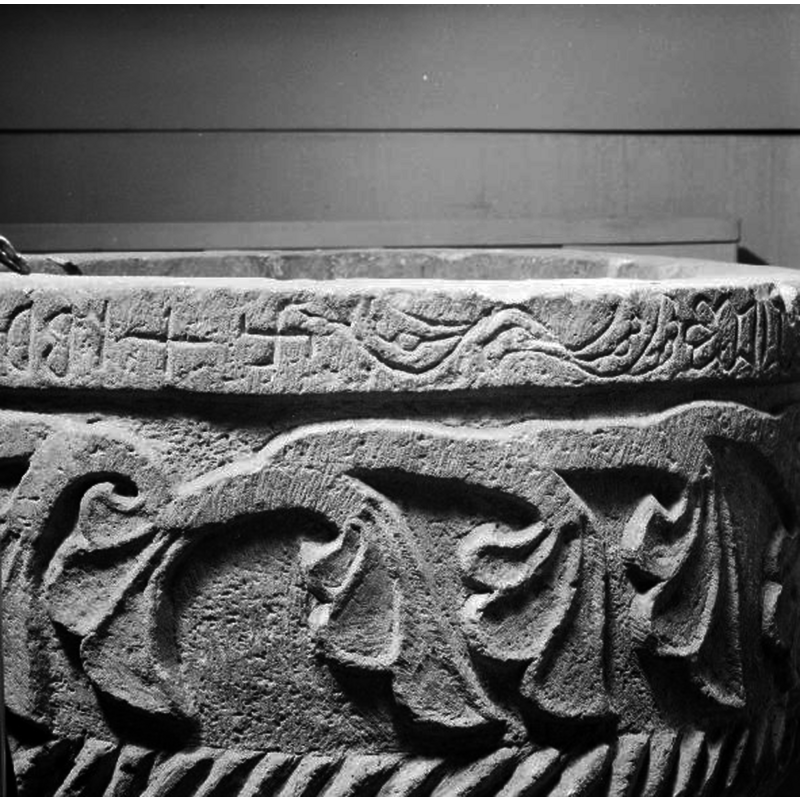 L--> R: Runic characters --> Greek cross --> Svastika cross --> scroll or vine --> floral, etc. -- Source caption: "Dopfunt, sandsten, 1200-talet, detalj av inskription och dekoration på cuppan."