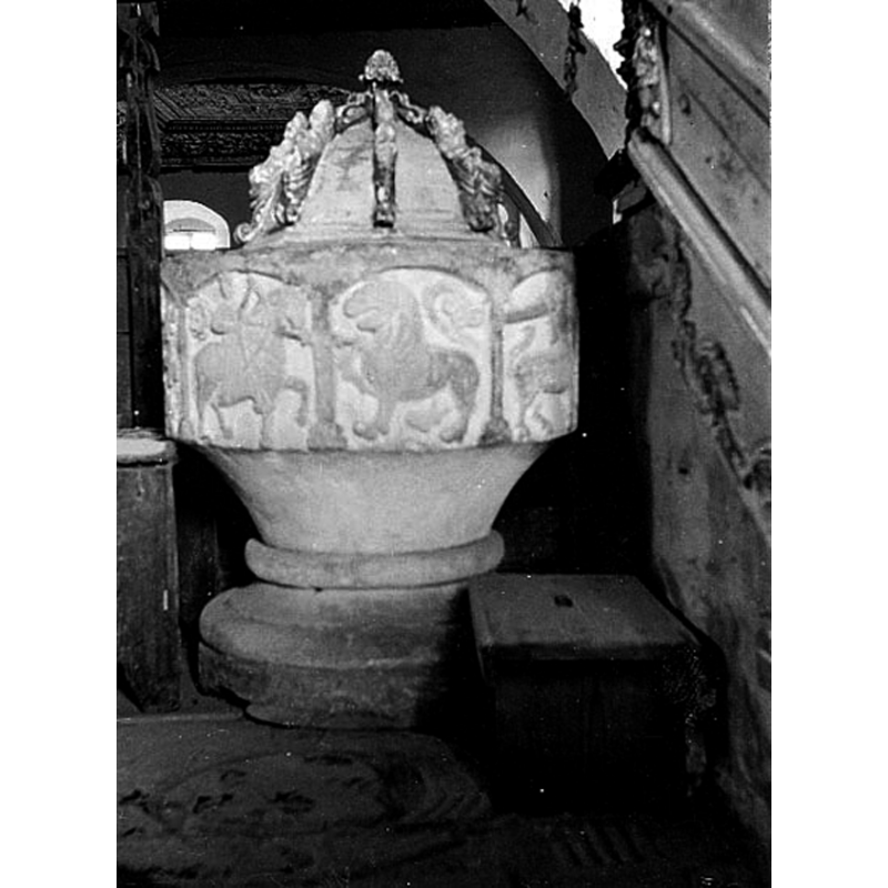 the font is shown in this 1911 photograph near the pulpit, against the wall; it would have been the south wall in the canonical orientation of this church but it had been altered in the 18thC century, when the chancel was pointed south -- Source caption: "Västerplana kyrka. Dopfunt."