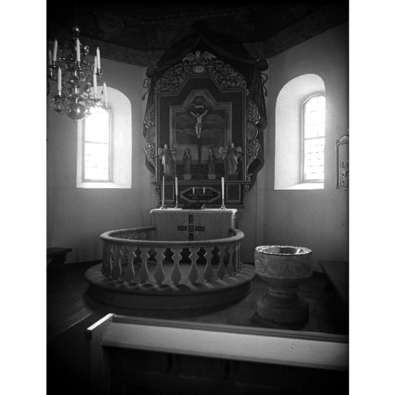 the medieval font seen here after the 1950 restoration of the church, at the east end, just right [south] of the communion railing -- Source caption: "Algutstorps kyrka [...] Interiör mot öster och koret. Efter restaurering."