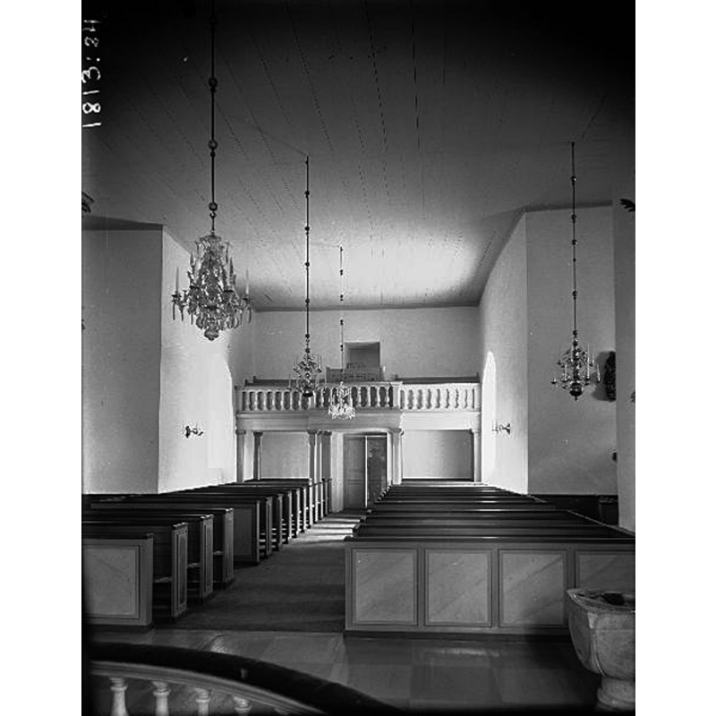 the medieval font is partially visible in the foreground, right [north] side -- Source caption: "Sveneby kyrka [...] Interiör mot väster. Efter restaureringen 1936."