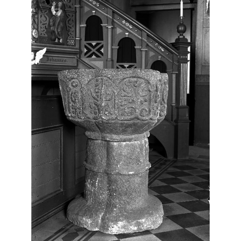 the medieval font by the pylpit stairs; taken probably after the 1926 renovation of the church -- Source caption: "Surteby-Kattunga, Surteby kyrka [...] Dopfunt, kalksten, 1200-talet."