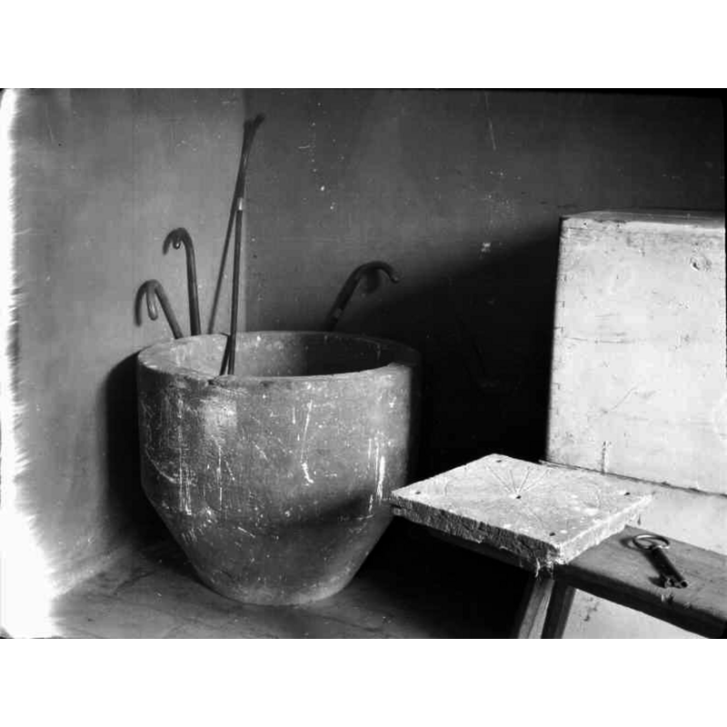 Source caption: "Ås kyrka [...] Dopfuntscuppa, sandsten.} [NB: the position of the old basin in this 1927 photograph, the walking sticks, the bench and the old key suggest a location near the [west?] entranceway -- the old basin was obviously disused at the time, while a later font in use, as shown in ImageFileNo. 0200925012]