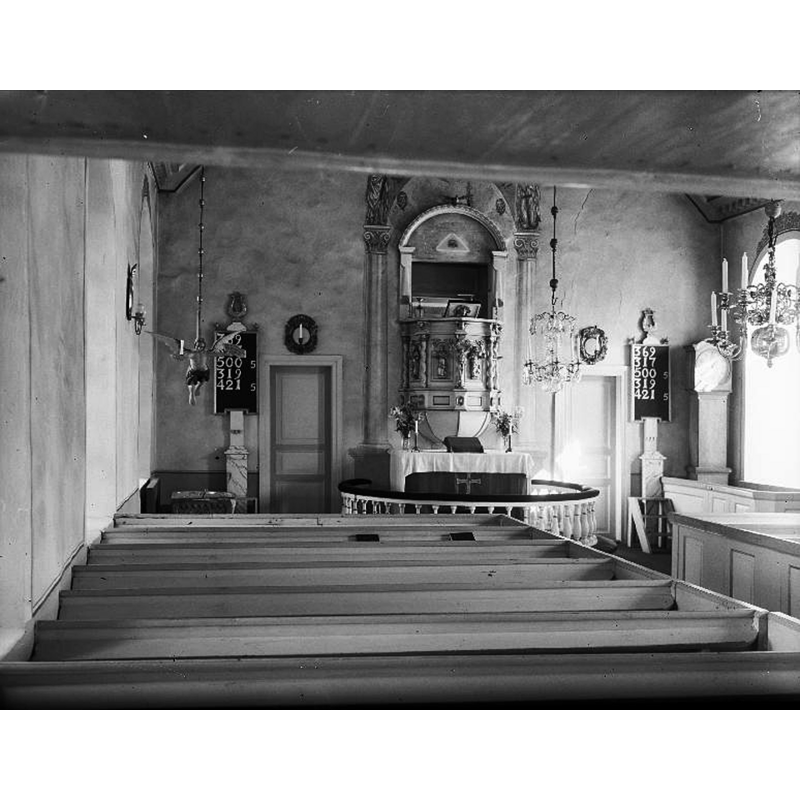 the medieval font is partially visible at the far [east] end, left [north] side, with the baptismal angel floating above