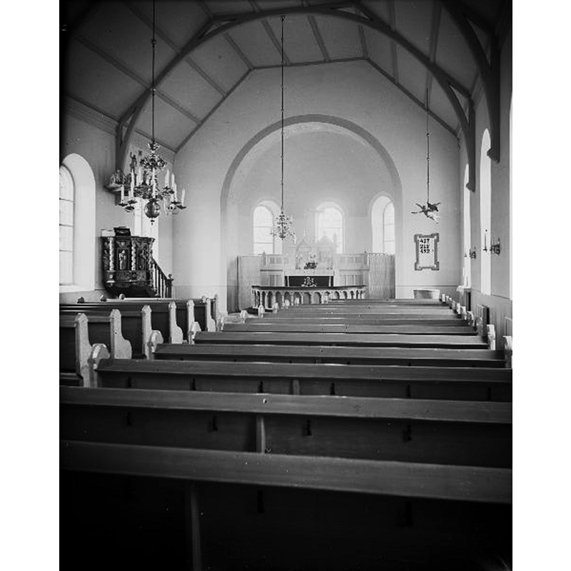 Source caption: "Kymbo [nya] kyrka [...] Interiör mot öster. Efter renovering." [NB: the medieval font is partially visible in the far [east] right [south] corner of the nave, by the psalm board, beneath the floating angel
