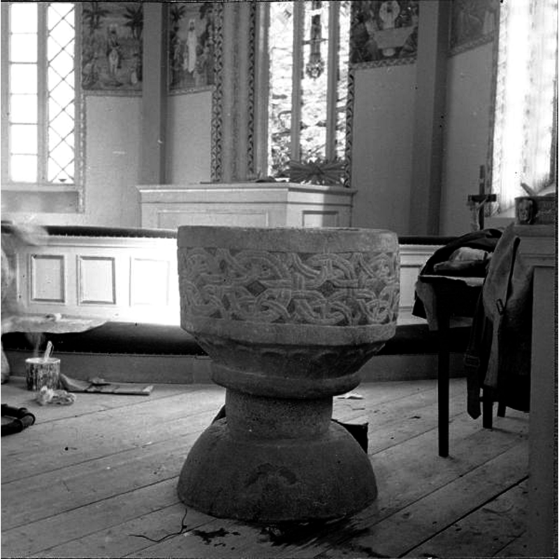 Source caption: "Fotskäls kyrka [...] Dopfunt, sandsten, senare delen av 1100-talet." [NB: the context suggests the photograph may have been taken during the 1955 interior renovation of the church]