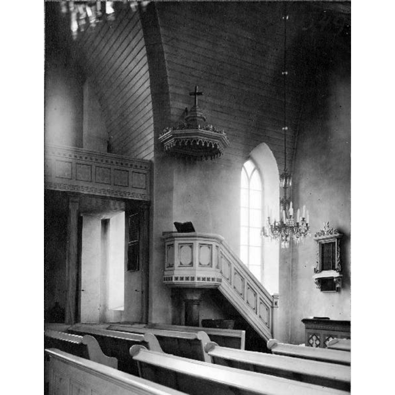the medieval font is partially visible by the pulpit