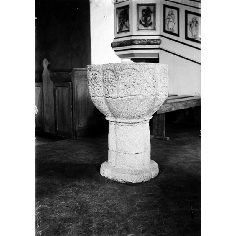 Source caption: "Landvetters kyrka [...] Dopfunt av grå kalksten, 1300-talet." -- the photograph was taken before the restauration; at the time the baptismal font was on the north side of the nave, near the pulpit