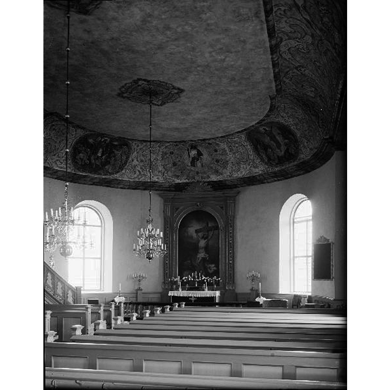 Source caption: "Toarps kyrka [...] Interiör mot nordöst, efter renovering 1955." -- the top of the medieval font is discernible at the far [east] end of the right [south] bank of pews