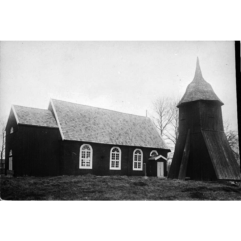 Source caption: "Ölsremma kyrka [...] Kyrkans södra sida och klockstapeln, med inbyggd huv. Observera dopfunten som står vid vapenhuset." -- as the caption indicates, the font stands outside by the west entrance of the church