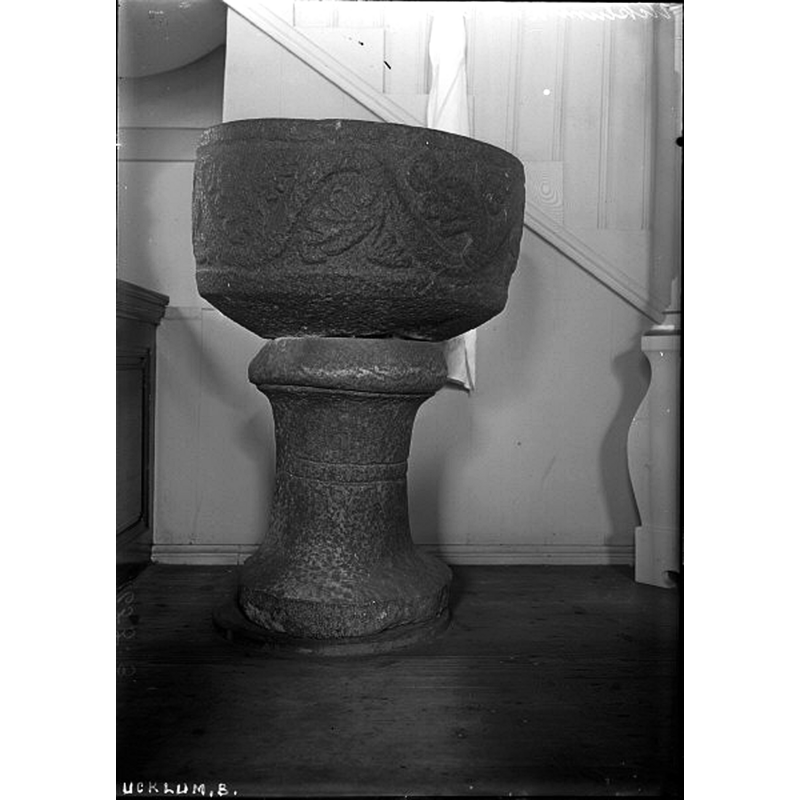 Source caption: "Ucklums kyrka [...] Dopfunt av svart granit," [NB: according to the SHM entry the basin is made of gneiss stone, the pedestal of limestone [cf. FontNotes]]