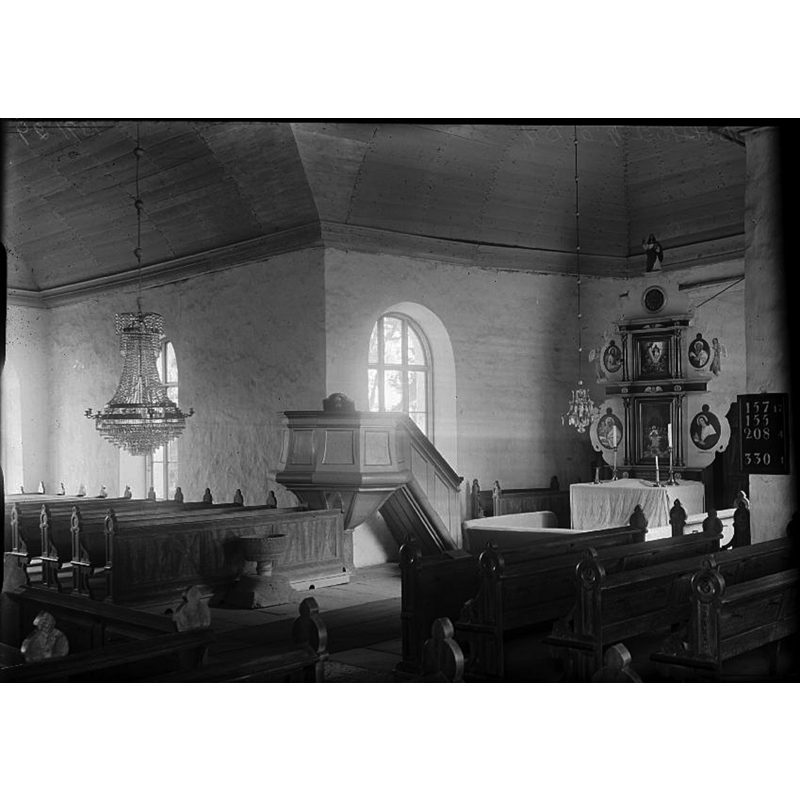 the medieval font stands at the east end of the bank of pews
