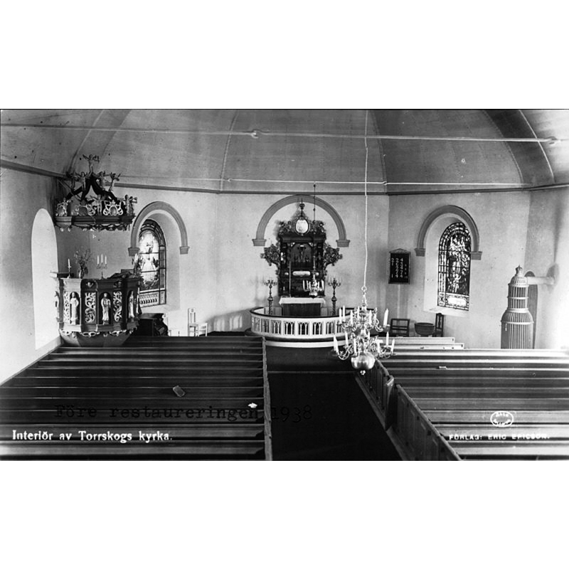 Source caption: "Torrskogs kyrka [...] Interiör mot öster, före restaureringen 1938. Vykort." -- showing the medieval font on the right [south] side, by the window