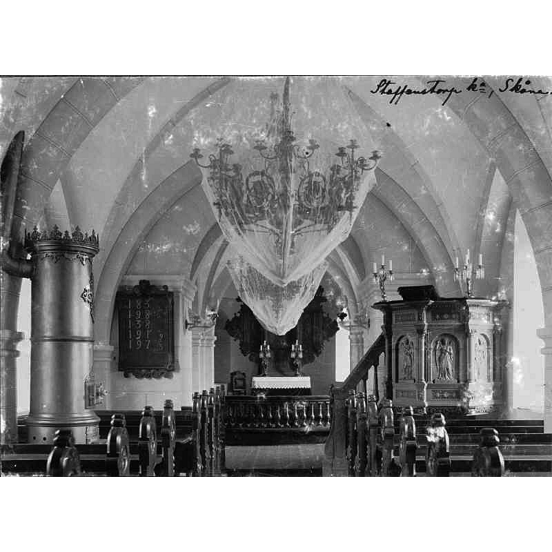 Source caption: "Brågarps kyrka [...] Interiör mot öster." -- showing the interior before the large renovation that changed completely the aspect of the interior, including moving the pulpit to the north side, replacing all the nave and chancel furnishings, etc.