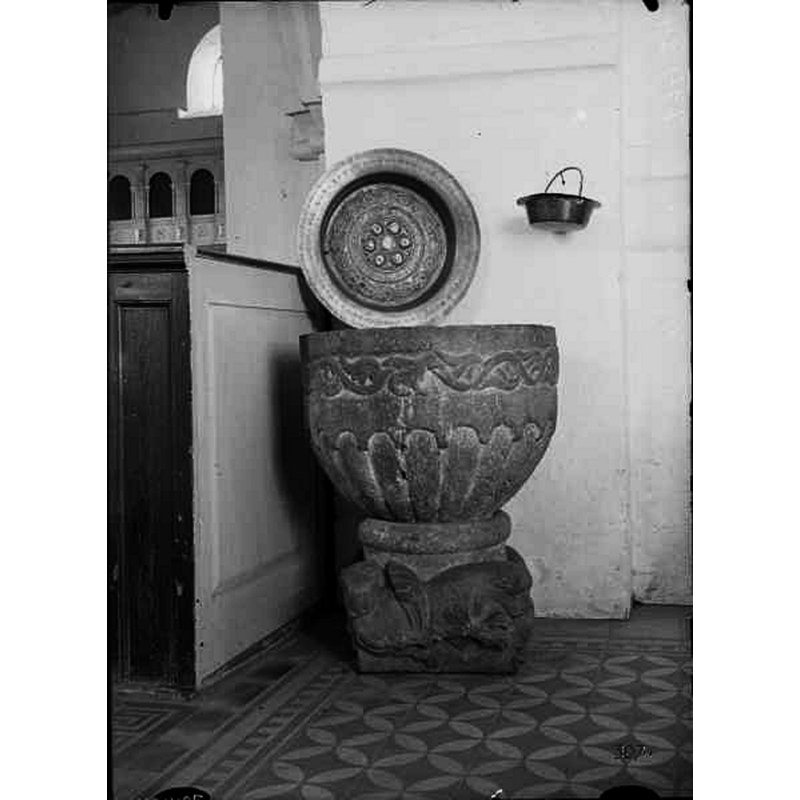 Source caption: "Dopfunt av sandsten, cylindrisk cuppa, fyrsidig fot. Omkring 1200. Dopfat av punsad driven mässsing, 1500-talet, vapensköldar och initialer troligen 1600-talet."