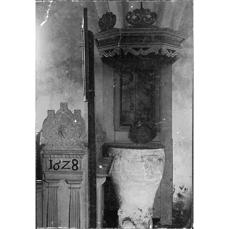 Source caption: "Stora Hammars gamla kyrka [...] Dopfunt av sandsten. Mårtens skola, 1100-talets slut." -- the font stands behind the psalm board so, presumably, near or in the chancel area; the object standing on top of the font could be the baptismal dish