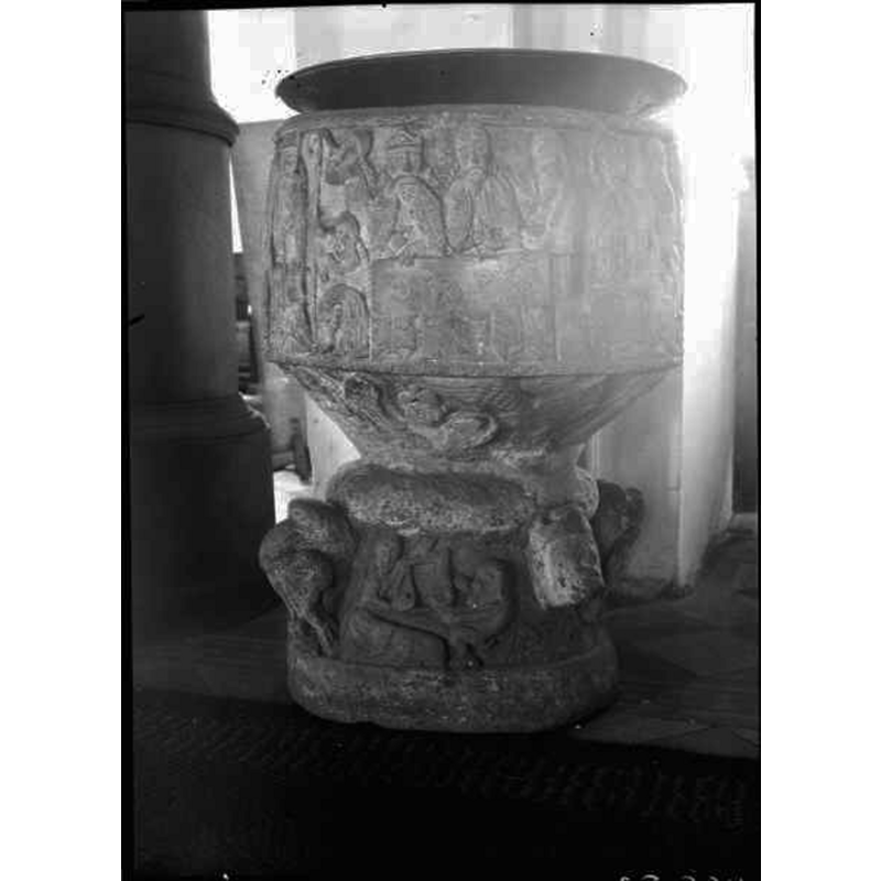 Source caption: "Östra Hoby kyrka [...] Dopfunt av sandsten, cylindrisk, av Magister Majestatis, 1100-talet." -- the object on top is probably the baptismal dish