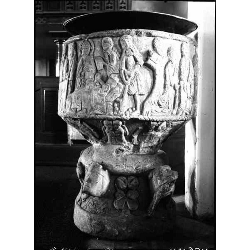 Source caption: "Östra Hoby kyrka [...] Dopfunt av sandsten, cylindrisk, av Magister Majestatis, 1100-talet." -- the object on top is probably the baptismal dish