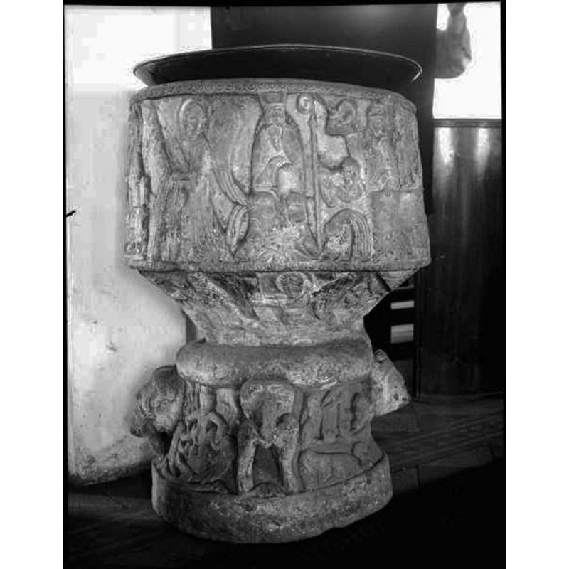 Source caption: "Östra Hoby kyrka [...] Dopfunt av sandsten, cylindrisk, av Magister Majestatis, 1100-talet." -- the object on top is probably the baptismal dish