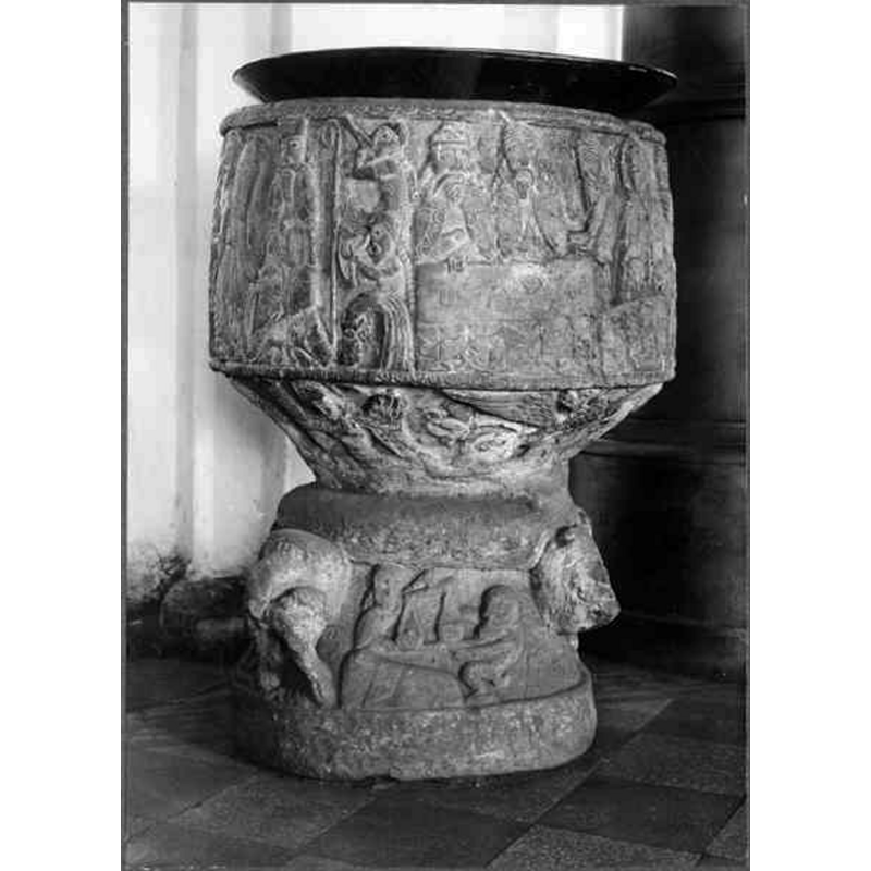 Source caption: "Östra Hoby kyrka [...] Dopfunt av sandsten, cylindrisk, av Magister Majestatis, 1100-talet." -- the object on top is probably the baptismal dish