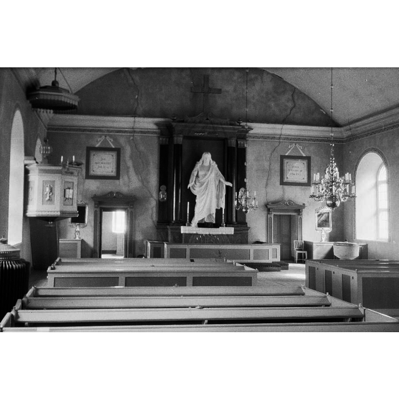Source caption: "Hagby kyrka [...] Interiör mot öster." -- showing the baptismal font in the southeast corner of the nave
