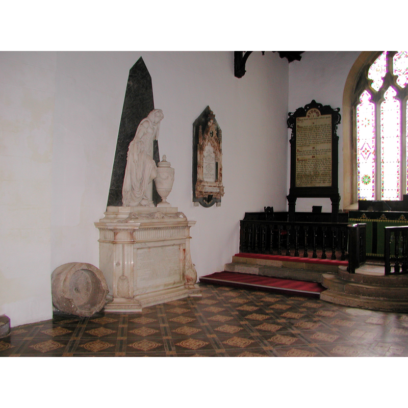the old font can be seen against the north wall, to the left (west) of the marble monument