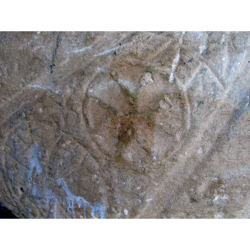 in the upright position this symbol would be slightly below and to the left of another symbol with what appears to be a four-leaf symbol inscribed in a circle