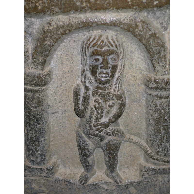 In the second arch from the right: a naked woman who holds the body of a snake with her left hand; the snake appears to be biting her left breast; her right hand is raised to her cheek (Luxuria? or Eve?)