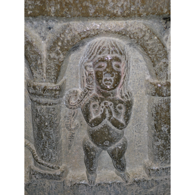 this woman looks similar to the one in the previous arcade: she is totally naked and in the same frontal position; her hands are crossed in prayer but she has a smake at her right ear