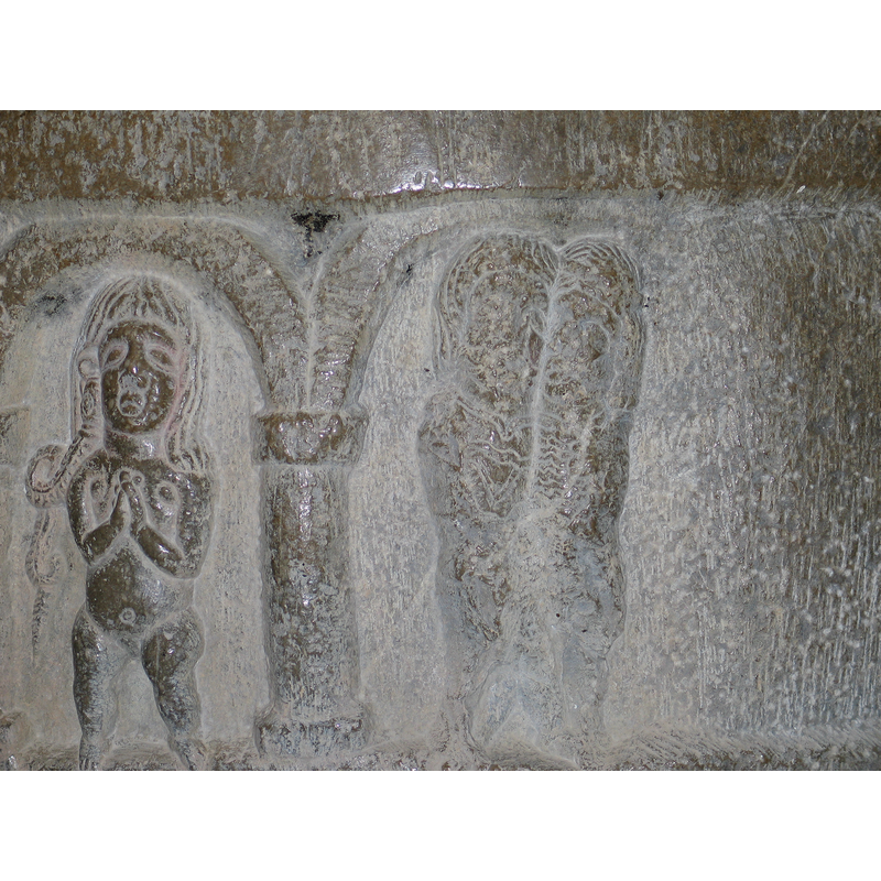 under the unfinished arch of the extreme right stand what appear to be two human figures very close to each other; the scene is clearly unfinished, as is the arch in which they stand, and there is not enough evidence to define them as male or female, though they are confronted as if they were a couple