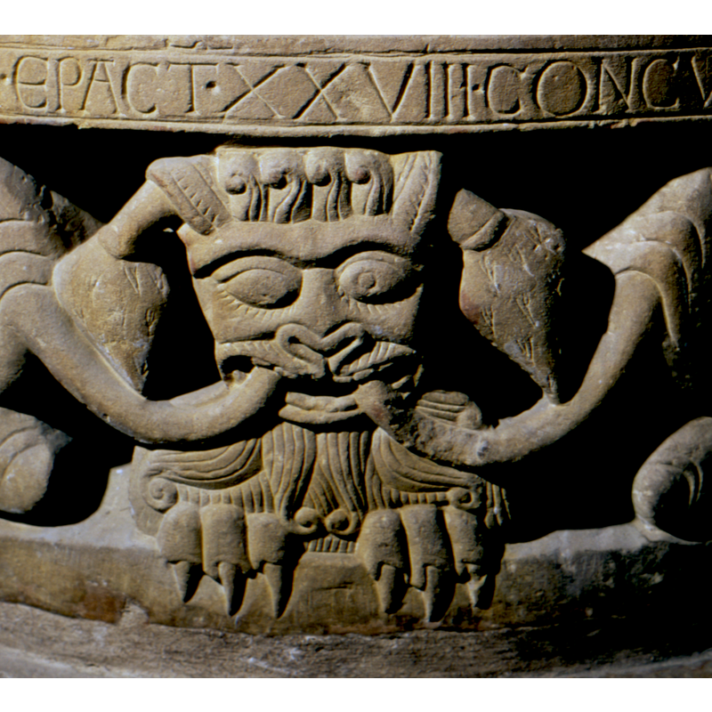 monster? lion?: the tails of two lions enter his mouth and come out of its ears