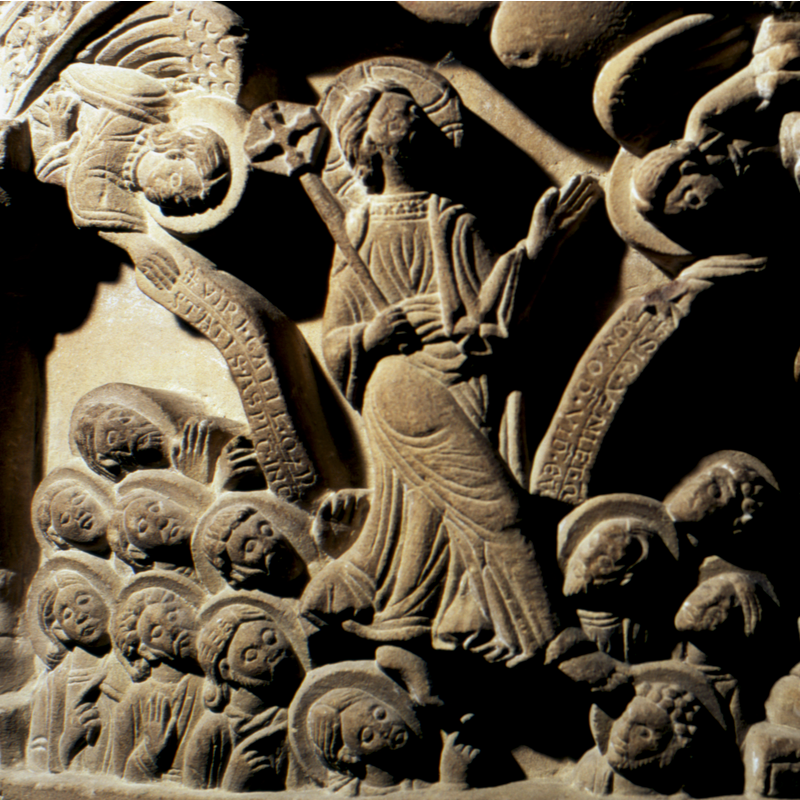 the two angels hold inscribed scrolls; Christ has cruciferous nimbus; Apostles'heads are haloed too