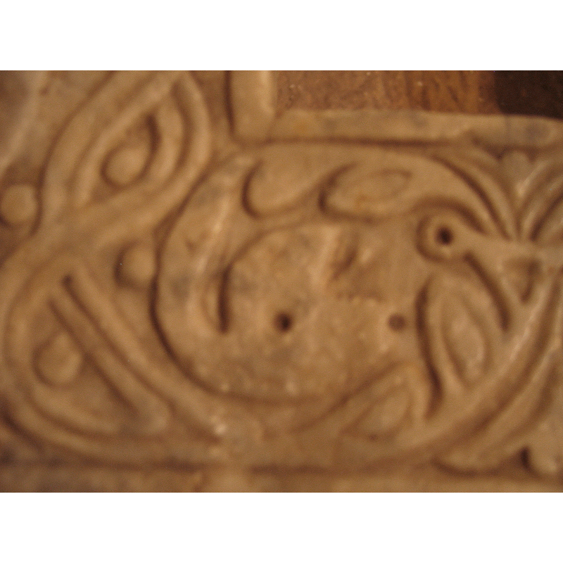 another serpent head on the upper rim
