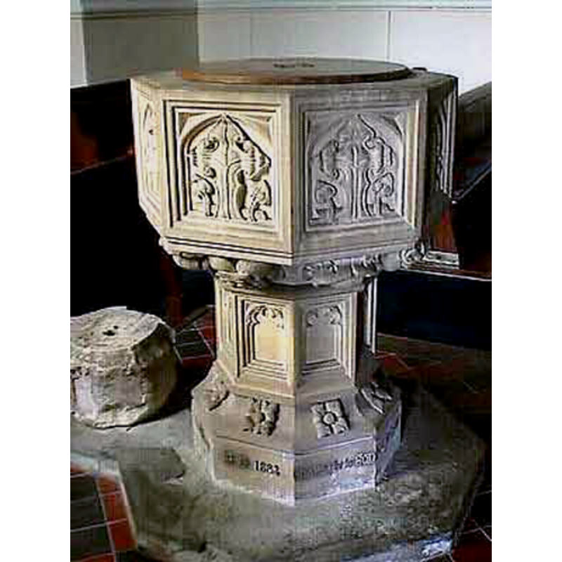 the fragment -part of the base- of the 15th-century font, on the plinth kneeling extension; to its right the 19th-century replacement font