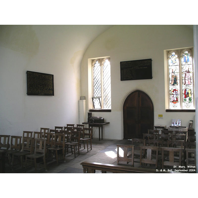 the baptismal font is located to the right of the west door, under the right window