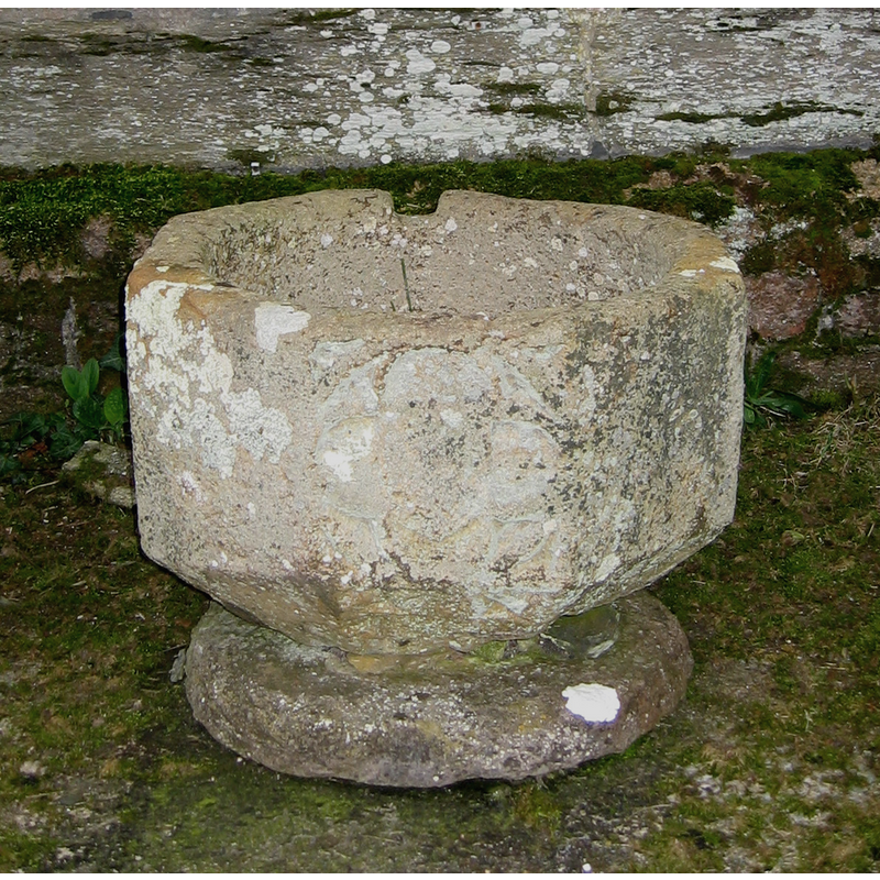 the 15th-century (?) font in its present location outside the church; notice the missing stem