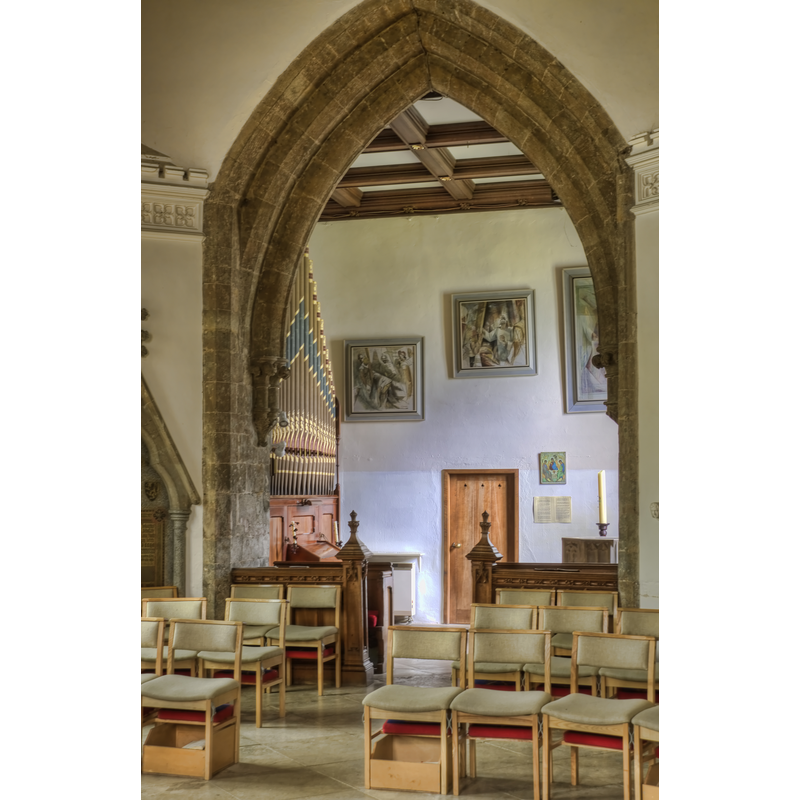 the font partly visible on the right, behind the wall, by the baptismal candle